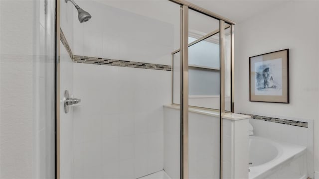 bathroom featuring shower with separate bathtub