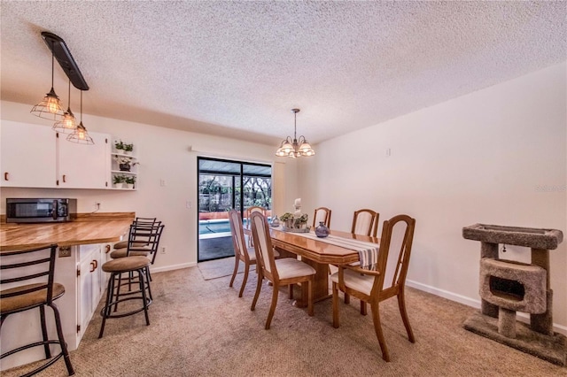 carpeted dining room featuring a textured ceiling and a notable chandelier