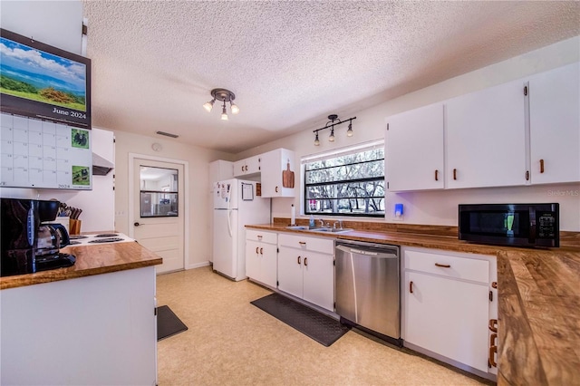 kitchen featuring dishwasher, white refrigerator, sink, a textured ceiling, and white cabinetry