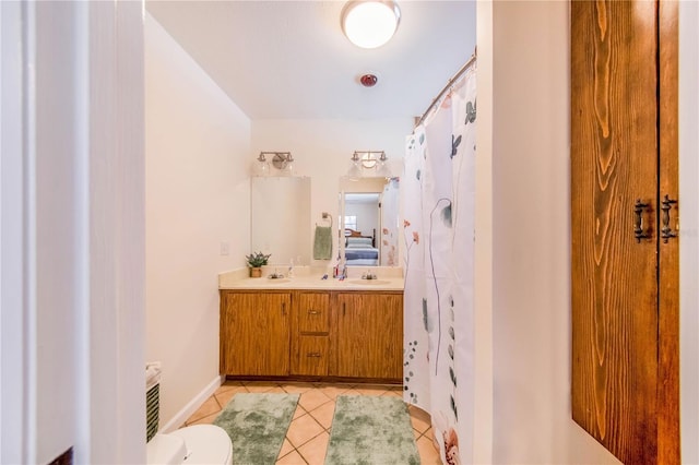 bathroom with tile patterned flooring, vanity, and toilet