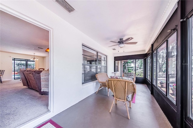 sunroom with ceiling fan with notable chandelier