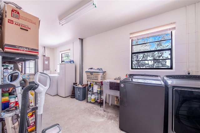 clothes washing area featuring electric panel, washer and clothes dryer, and sink