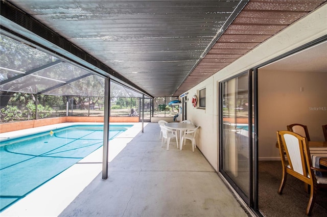 view of swimming pool with glass enclosure and a patio