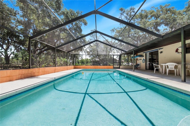 view of swimming pool featuring a patio and a lanai