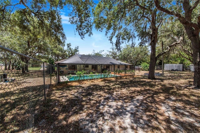 view of yard with a fenced in pool and glass enclosure