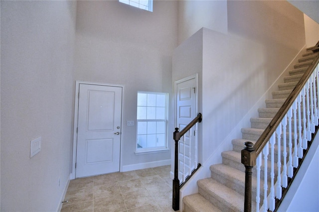 stairway featuring a towering ceiling