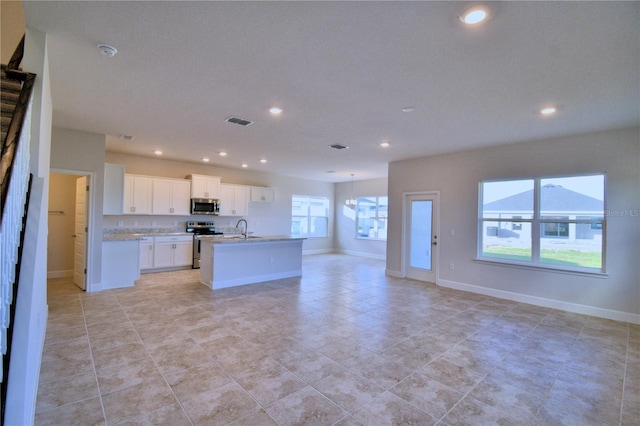 kitchen featuring white cabinetry, a center island with sink, sink, and appliances with stainless steel finishes