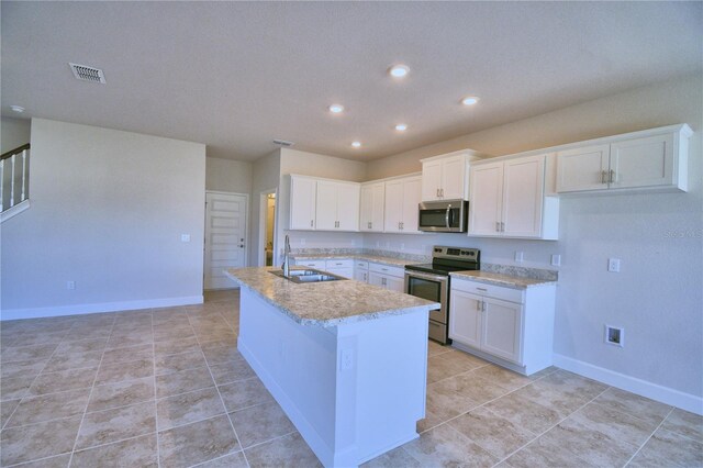 kitchen featuring sink, stainless steel appliances, light tile patterned floors, an island with sink, and white cabinets