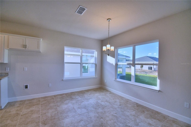 unfurnished dining area featuring a chandelier