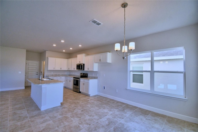 kitchen with stainless steel appliances, sink, white cabinetry, hanging light fixtures, and an island with sink