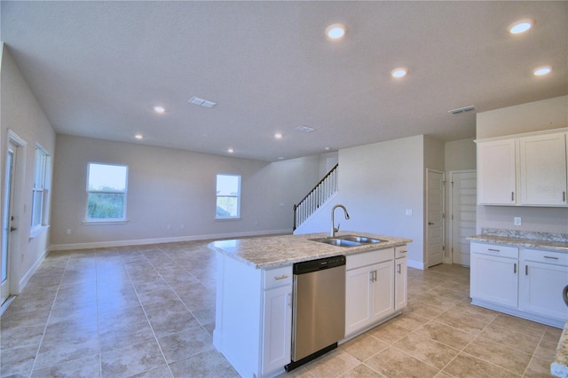 kitchen featuring light stone counters, stainless steel dishwasher, a kitchen island with sink, sink, and white cabinets