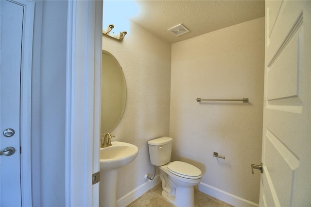 bathroom featuring tile patterned floors, sink, a textured ceiling, and toilet