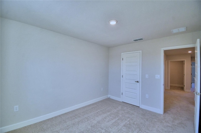 unfurnished bedroom with light colored carpet and a closet