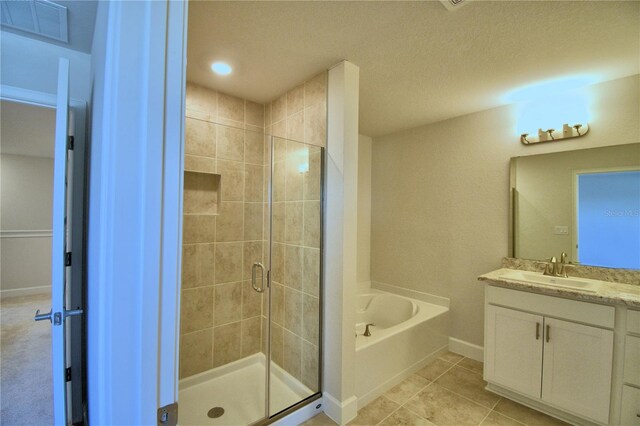 bathroom featuring tile patterned flooring, vanity, and separate shower and tub