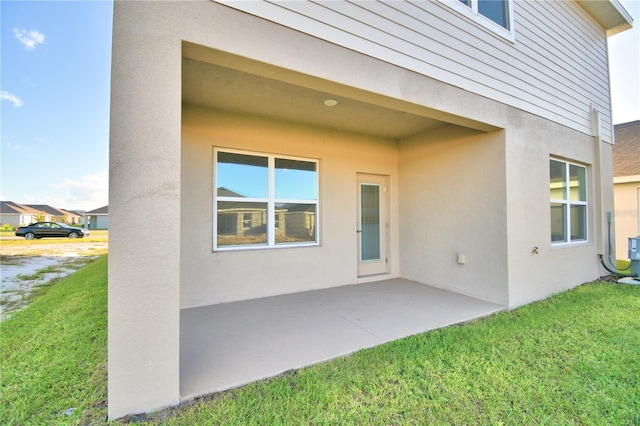 rear view of house featuring a patio and a lawn