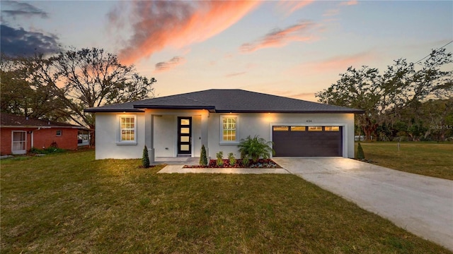 prairie-style house featuring a garage and a yard