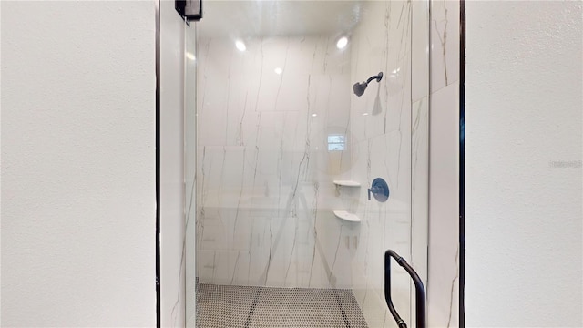 bathroom featuring a shower with shower door