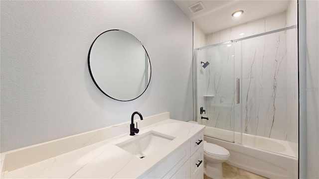 full bathroom with shower / bath combination with glass door, vanity, and toilet