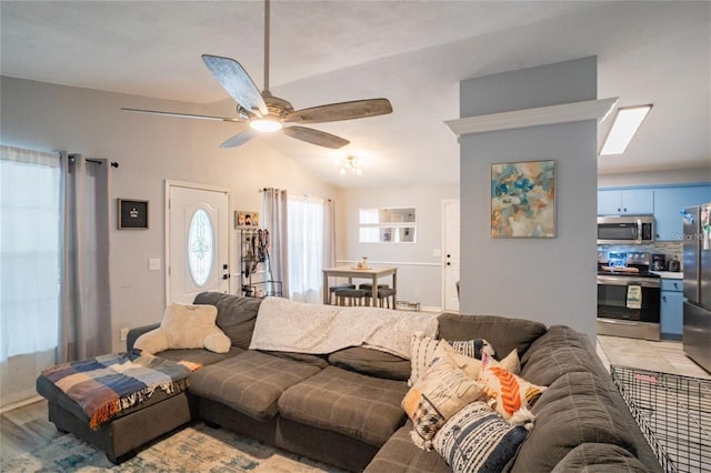 living room featuring ceiling fan, vaulted ceiling, and light hardwood / wood-style flooring