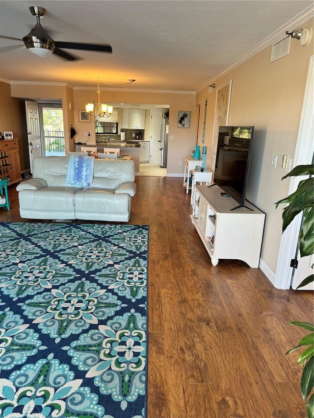 living room with ornamental molding, ceiling fan with notable chandelier, and hardwood / wood-style flooring