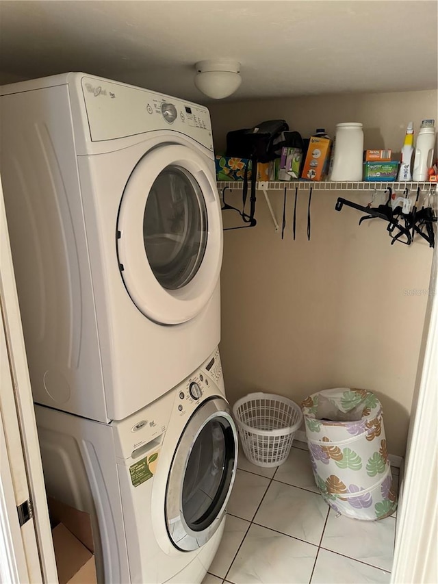 laundry room featuring light tile patterned floors and stacked washer / drying machine