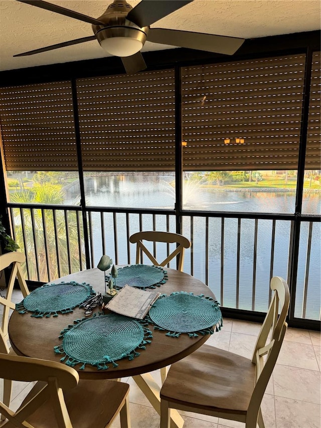 sunroom / solarium with a water view, plenty of natural light, and ceiling fan