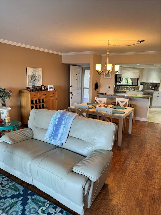 living room with hardwood / wood-style flooring, crown molding, and an inviting chandelier