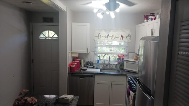 kitchen with appliances with stainless steel finishes, white cabinetry, a wealth of natural light, and ceiling fan