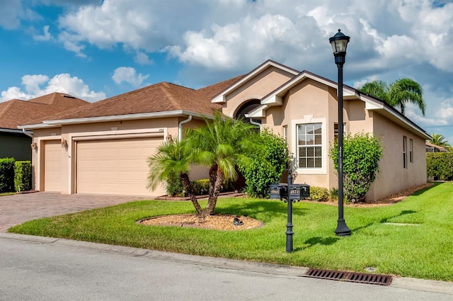 ranch-style house with decorative driveway, an attached garage, a front lawn, and stucco siding