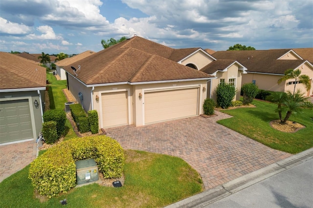 ranch-style home with a garage, a front lawn, and central air condition unit