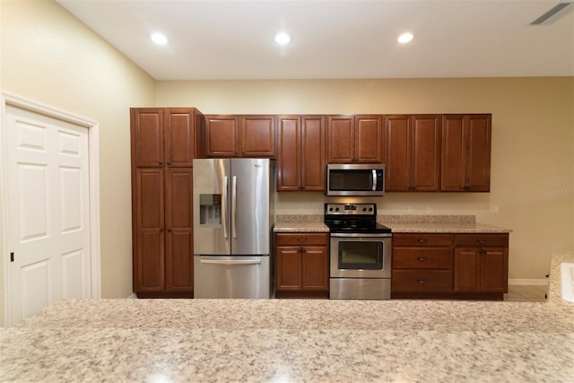 kitchen featuring light stone countertops and stainless steel appliances