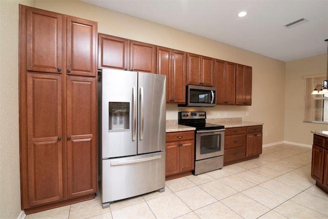 kitchen with light tile patterned flooring, stainless steel appliances, a chandelier, and light stone countertops