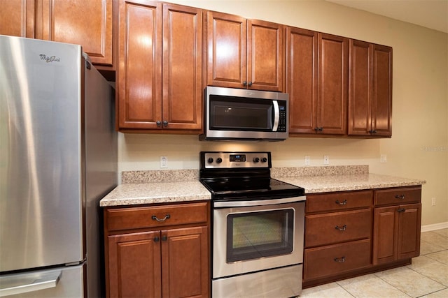 kitchen with light tile patterned floors and appliances with stainless steel finishes