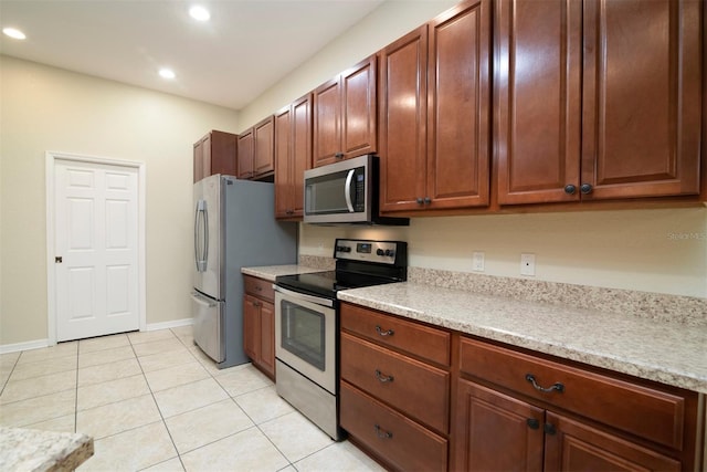 kitchen with light tile patterned floors and stainless steel appliances