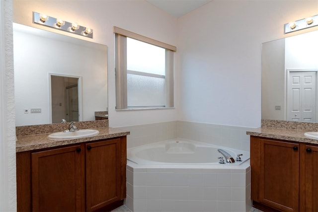 bathroom with vanity and tiled tub