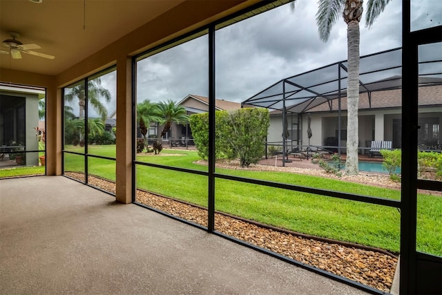 unfurnished sunroom with ceiling fan