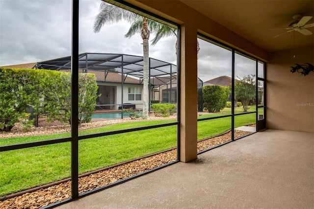 unfurnished sunroom with ceiling fan