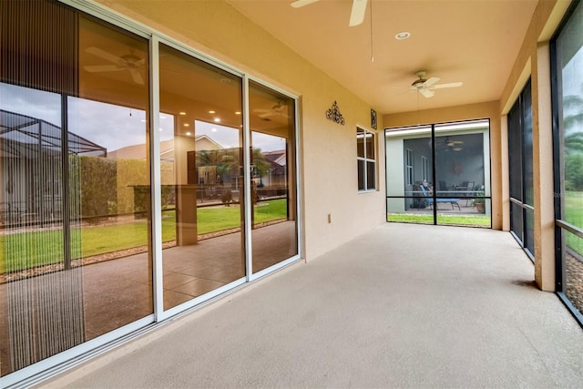 unfurnished sunroom with ceiling fan