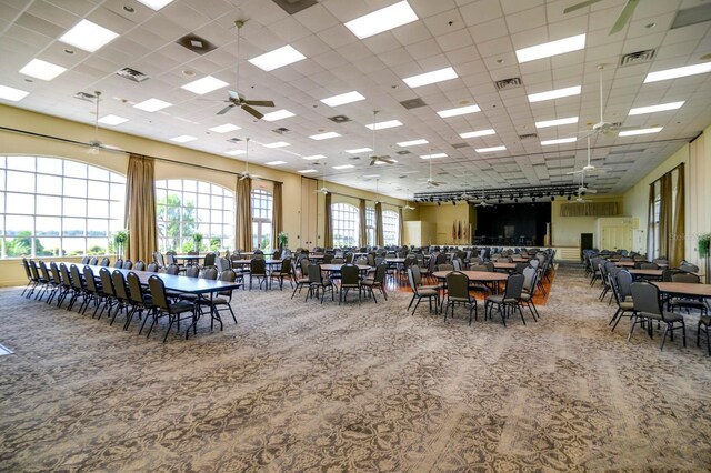 dining room featuring ceiling fan, a paneled ceiling, and a healthy amount of sunlight