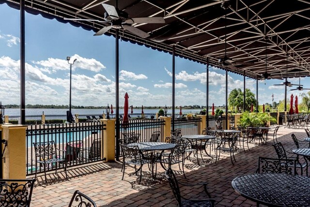 view of patio / terrace with ceiling fan, a community pool, and a water view