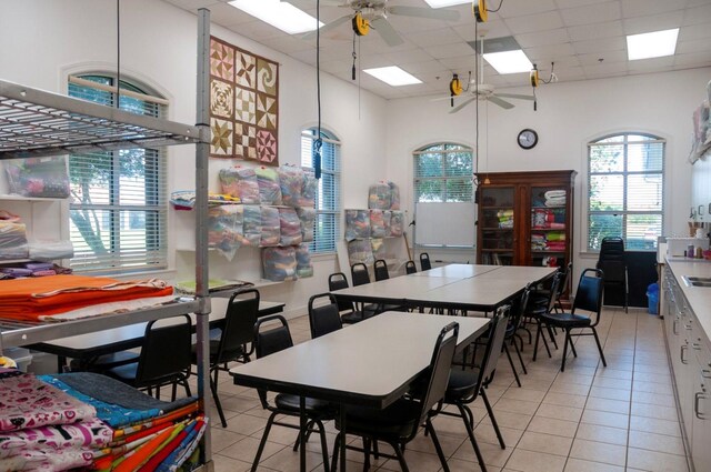 dining area featuring ceiling fan, light tile patterned floors, and a drop ceiling