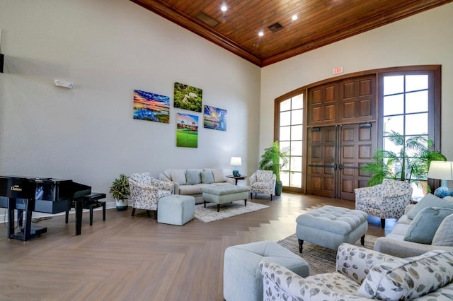 living area featuring wooden ceiling, a high ceiling, visible vents, baseboards, and crown molding
