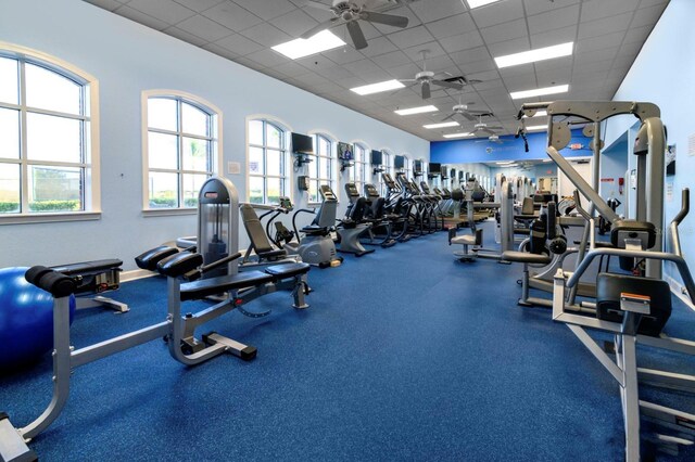 exercise room with a paneled ceiling and ceiling fan