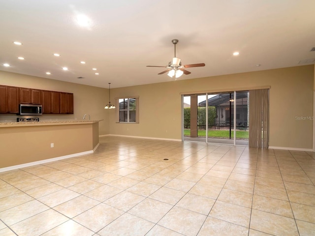 unfurnished living room with ceiling fan and light tile patterned flooring