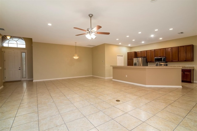 kitchen featuring light tile patterned floors, stainless steel appliances, a center island with sink, and ceiling fan