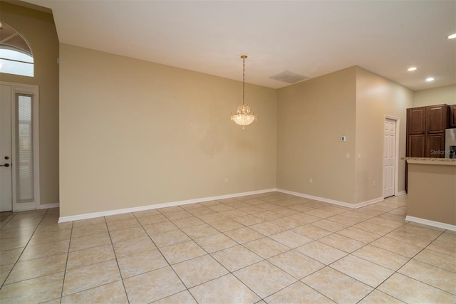 unfurnished room featuring light tile patterned floors and a notable chandelier