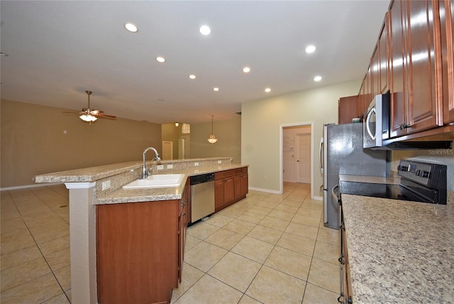 kitchen with appliances with stainless steel finishes, sink, hanging light fixtures, a kitchen breakfast bar, and light tile patterned flooring