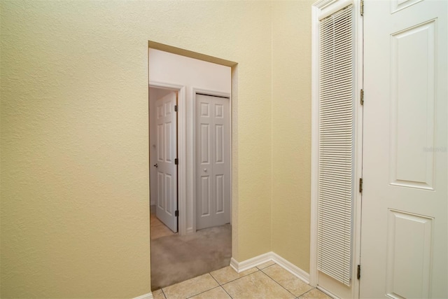 hall featuring light tile patterned floors