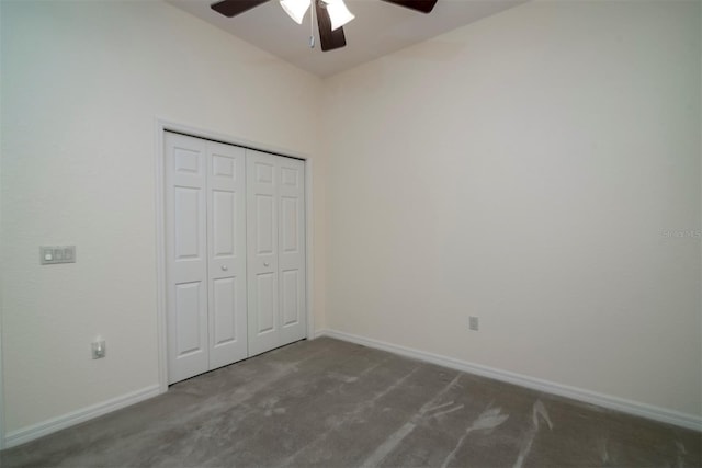 unfurnished bedroom with ceiling fan, a closet, and dark colored carpet