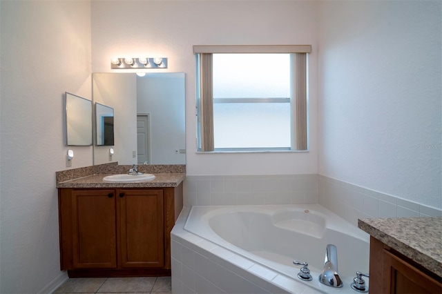 bathroom featuring tile patterned floors, tiled tub, and vanity